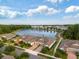 Aerial view of homes near a lake and green spaces, with blue skies and scattered clouds above at 16866 Balance Cv, Land O Lakes, FL 34638