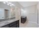 Bathroom featuring double vanities, granite countertops, and decorative lighting at 16866 Balance Cv, Land O Lakes, FL 34638