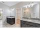 Bathroom featuring double vanities, granite countertops, and decorative lighting at 16866 Balance Cv, Land O Lakes, FL 34638