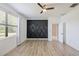 Modern bedroom with a decorative accent wall and hardwood flooring at 16866 Balance Cv, Land O Lakes, FL 34638