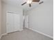 Bedroom with a ceiling fan, neutral gray carpet, a closet and an open doorway at 16866 Balance Cv, Land O Lakes, FL 34638
