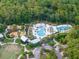 Aerial view shows multiple community pools, playground, and community buildings at 16866 Balance Cv, Land O Lakes, FL 34638