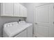 Bright laundry room features a white washer and dryer, white cabinets, and neutral paint at 16866 Balance Cv, Land O Lakes, FL 34638