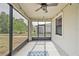 Screened patio area with view of the home's yard and a ceiling fan above at 16866 Balance Cv, Land O Lakes, FL 34638