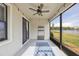 This is a screened patio with a ceiling fan and views of the lake at 16866 Balance Cv, Land O Lakes, FL 34638