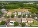 Aerial view of a residential area with mature trees and a tranquil pond in the distance at 18424 Cypress Bay Pkwy, Land O Lakes, FL 34638