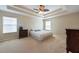 Bedroom with tray ceiling, plush carpet, and bright, natural light at 18424 Cypress Bay Pkwy, Land O Lakes, FL 34638