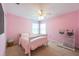 Bright bedroom featuring pink walls, plush carpet, and a ceiling fan for added comfort at 18424 Cypress Bay Pkwy, Land O Lakes, FL 34638