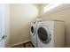 Bright laundry room featuring modern washer and dryer, and practical storage shelf at 18424 Cypress Bay Pkwy, Land O Lakes, FL 34638