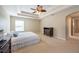 Spacious main bedroom with tray ceiling, fan and neutral decor, with an ensuite bathroom entrance at 18424 Cypress Bay Pkwy, Land O Lakes, FL 34638
