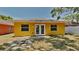 Exterior backyard with mature trees, white fence, and sliding glass doors at 1850 Fuller Dr, Clearwater, FL 33755