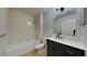 Updated bathroom features a tub, shower, and a dark vanity at 1850 Fuller Dr, Clearwater, FL 33755