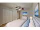 Bedroom with modern decor, featuring a white dresser, closet, ceiling fan and soothing color palette at 1850 Fuller Dr, Clearwater, FL 33755