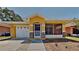 Charming single-story home featuring a yellow exterior, screened porch, attached garage, and well-maintained landscaping at 1850 Fuller Dr, Clearwater, FL 33755