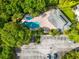 Aerial view of the community pool, parking lot, and lush greenery surrounding the complex at 1936 Heron Cove Dr # 104, Lutz, FL 33549