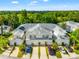 Stunning aerial view of townhomes with garages, palm trees, and a beautiful green landscape at 1936 Heron Cove Dr # 104, Lutz, FL 33549