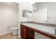 Bathroom featuring a granite vanity with a wood base and toilet in an alcove at 1936 Heron Cove Dr # 104, Lutz, FL 33549