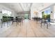 Spacious tiled clubhouse with chairs, tables, and stone counter with lush outside views at 1936 Heron Cove Dr # 104, Lutz, FL 33549