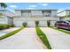 Charming townhome exterior with two stories, garages, and landscaped driveways at 1936 Heron Cove Dr # 104, Lutz, FL 33549