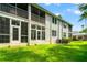 View of a two story condo with rear patios and backyard lawn at 1936 Heron Cove Dr # 104, Lutz, FL 33549