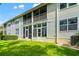 View of a two story condo with rear patios and backyard lawn at 1936 Heron Cove Dr # 104, Lutz, FL 33549