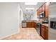 Open kitchen layout featuring wooden cabinets, stainless steel appliances, and stylish pendant lighting at 1936 Heron Cove Dr # 104, Lutz, FL 33549