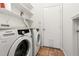 Clean laundry room with white washer and dryer, wire shelving, and a white door at 1936 Heron Cove Dr # 104, Lutz, FL 33549