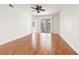 Spacious living room with hardwood floors, ceiling fan, and sliding glass doors at 1936 Heron Cove Dr # 104, Lutz, FL 33549