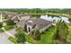 Beautiful aerial view of the home features mature landscaping, three-car garage and pond at 21642 Emory Oak Pl, Land O Lakes, FL 34637