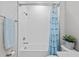 Bright bathroom with a white tiled shower, blue shower curtain and modern fixtures at 21642 Emory Oak Pl, Land O Lakes, FL 34637