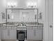 Elegant bathroom featuring double vanity with granite countertop, modern fixtures, and a central makeup station at 21642 Emory Oak Pl, Land O Lakes, FL 34637