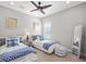 Cozy bedroom featuring two twin beds with blue and white bedding, a ceiling fan, and ample natural light at 21642 Emory Oak Pl, Land O Lakes, FL 34637