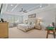 Comfortable bedroom with tray ceiling, neutral color scheme, and ample natural light from window at 21642 Emory Oak Pl, Land O Lakes, FL 34637
