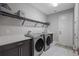 Functional laundry room with front load washer and dryer, ample counter space, and built-in storage shelving at 21642 Emory Oak Pl, Land O Lakes, FL 34637