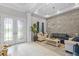 Elegant living room with stone accent wall, recessed lighting, and an open layout at 21642 Emory Oak Pl, Land O Lakes, FL 34637