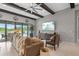 Spacious living room with comfortable sectional, beamed ceilings, and outdoor views at 21642 Emory Oak Pl, Land O Lakes, FL 34637