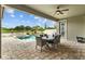 Covered patio with an outdoor dining area overlooking the pool and lake at 21642 Emory Oak Pl, Land O Lakes, FL 34637