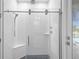 Modern shower room with glass door, white textured tile walls, and rain shower head at 21642 Emory Oak Pl, Land O Lakes, FL 34637
