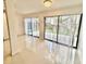 Bright living room featuring white tile floors, a sliding glass door, and plenty of light at 2233 Springwood W Cir, Clearwater, FL 33763