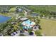 Aerial view of community pool, playground, and amenities surrounded by scenic lakes and greenery at 2903 Cypress Bowl Rd, Lutz, FL 33558