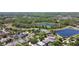 Wide aerial view showing a neighborhood with houses, trees, and picturesque lakes in the distance at 2903 Cypress Bowl Rd, Lutz, FL 33558