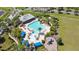Aerial view of community pool with blue cabanas and playground nestled among lush landscaping at 2903 Cypress Bowl Rd, Lutz, FL 33558
