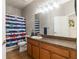 Bathroom with dark wood cabinets, tile flooring, large mirror, and shower with blue striped curtain at 2903 Cypress Bowl Rd, Lutz, FL 33558