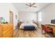 Well-lit bedroom with a ceiling fan, wood floors, and desk area for work or study at 2903 Cypress Bowl Rd, Lutz, FL 33558