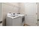 Laundry room featuring a white washer and dryer, wire shelf, and a white door at 2903 Cypress Bowl Rd, Lutz, FL 33558