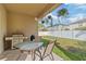 Covered patio with grill and table set, overlooking the fenced backyard at 2903 Cypress Bowl Rd, Lutz, FL 33558