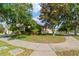 Landscaped yard with mature trees and a sidewalk lined with greenery at 2903 Cypress Bowl Rd, Lutz, FL 33558