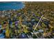 Aerial view shows a beautiful home surrounded by lush trees and a bay view at 3165 Renatta Dr, Belleair Bluffs, FL 33770