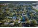 Aerial view of the property in a neighborhood with tree coverage near the shore at 3165 Renatta Dr, Belleair Bluffs, FL 33770