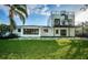 Expansive backyard with lush green lawn, modern architecture, and mature trees at 3165 Renatta Dr, Belleair Bluffs, FL 33770
